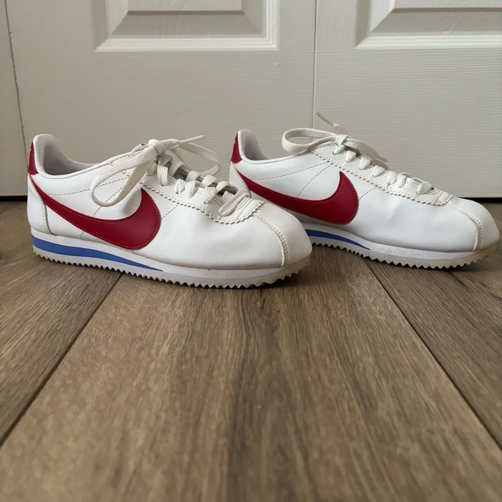 Nike Women's White Sneakers with Red Swoosh and Blue Accent